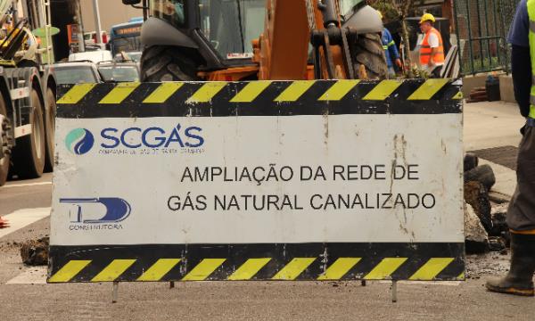 A SCGÁS inicia em setembro as obras de expansão da rede de distribuição do gás natural canalizado no bairro Trindade, em Florianópolis. Os trabalhos começam no dia 9 na Rua Professor Paschoal Apóstolo Pitsica, próximo ao Centro Integrado de Cultura (CIC). Com um investimento de R$ 2,4 milhões, a expansão será de aproximadamente 4,6 km de rede em PEAD (Polietileno de Alta Densidade). A previsão é que as obras sejam concluídas até dezembro deste ano.

As ruas pelas quais as obras vão passar são: Professor Paschoal Apóstolo Pitsica, Lauro Caldeira de Andrada, Procópio Manoel Pires, Iracema Nunes da Silva, Odilon Fernandes, Profª. Enoé Schutel, Osmarino de Deus Cardoso, Madre Benvenuta, Santa Luzia, Prof. Maria Flora Pausewang, Delfino Conti e Antônio Edu Vieira. 

A nova rede atenderá inicialmente cinco condomínios residenciais com a possibilidade de expandir o atendimento para outros empreendimentos residenciais e comerciais da região. O projeto permite a instalação de novas redes, que conectam diretamente diversos clientes. Entre os principais novos clientes estão o VIVA Trindade Comercial, o VIVA Trindade Residencial, MG Pinheiro, o supermercado Angeloni e o Villa Romana Shopping.

A companhia utiliza técnicas de construção de baixo impacto às vias, que reduzem a necessidade de abertura de valas, além de acelerar a implantação da rede, especialmente nos trechos mais críticos. O método não destrutivo (MND), que permite a perfuração guiada por sondas, reduz em muito a necessidade de abertura de valas, limitando estas aos pontos de início e fim de cada segmento. Uma recomposição provisória do pavimento será executada com lajotas sextavadas, e, após a conclusão dos testes de segurança da rede, será realizada a repavimentação asfáltica definitiva.

Podem ocorrer alterações pontuais no trânsito durante o período das obras. Estas, se ocorrerem, serão coordenadas com a Guarda Municipal de Florianópolis para garantir a segurança e a fluidez do tráfego. As intervenções ocorrerão diariamente, das 7h30 às 17h30.

A SCGÁS reforça seu compromisso em minimizar os impactos das obras para a comunidade e agradece a compreensão de todos. Para mais informações ou para reclamações relacionadas às obras, os moradores podem utilizar o canal 