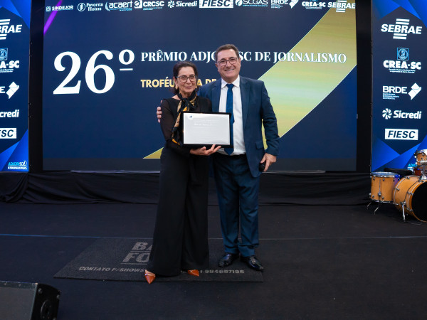 Jornalista Rita de Cássia recebe placa comemorativa do presidente da Adjori/SC José Roberto Deschamps