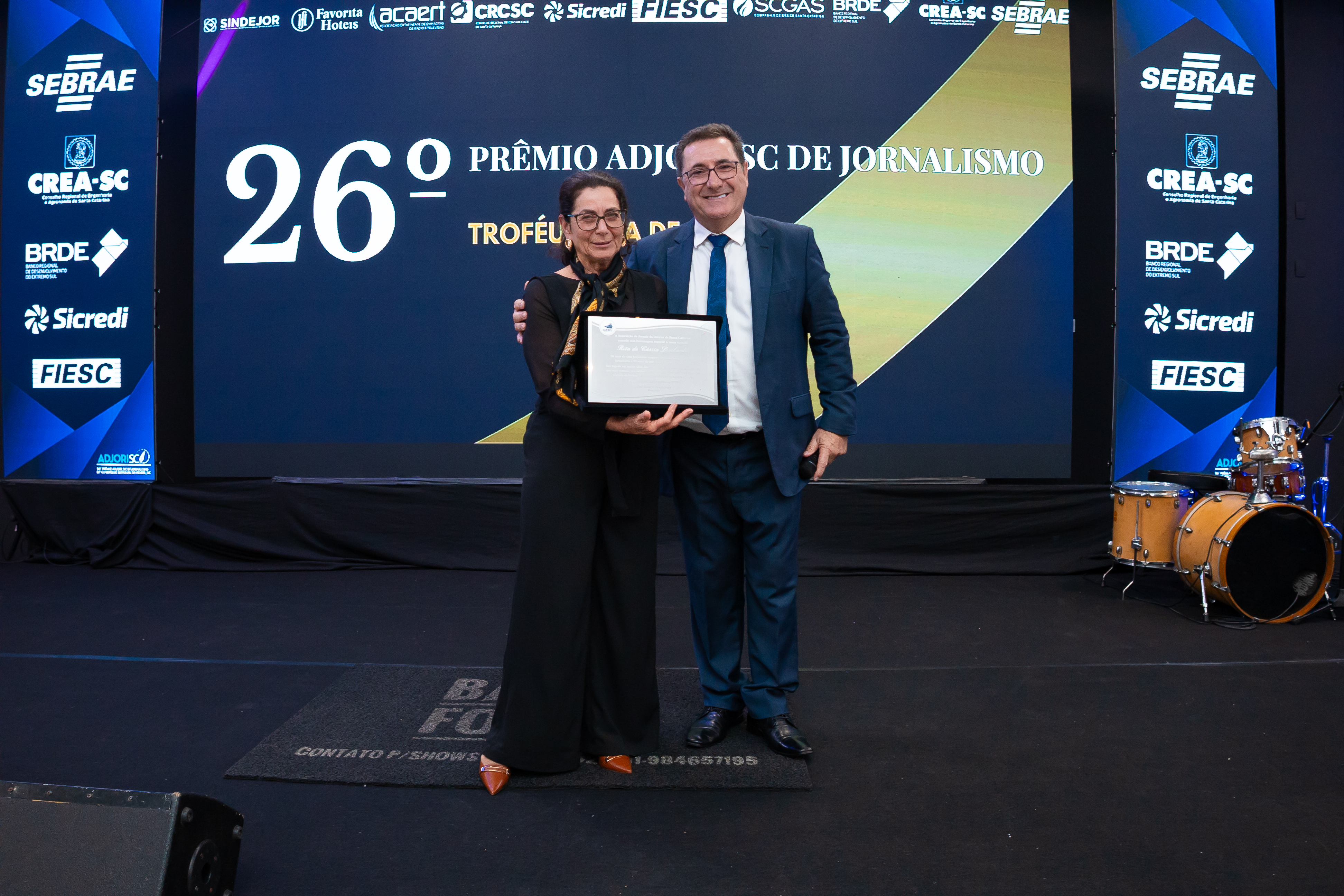 Jornalista Rita de Cássia recebe placa comemorativa do presidente da Adjori/SC José Roberto Deschamps