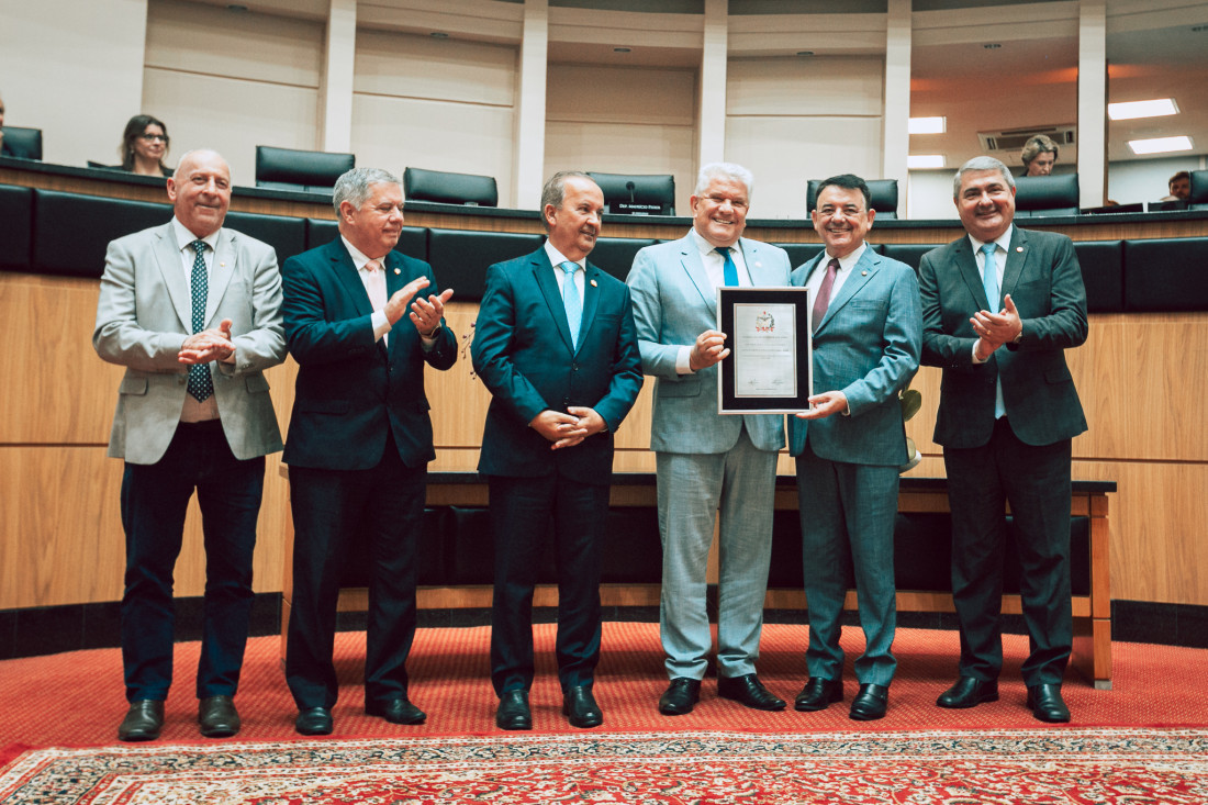 Ari Rabaiolli, presidente do Badesc, recebe placa comemorativa do deputado Maurício Peixer.
