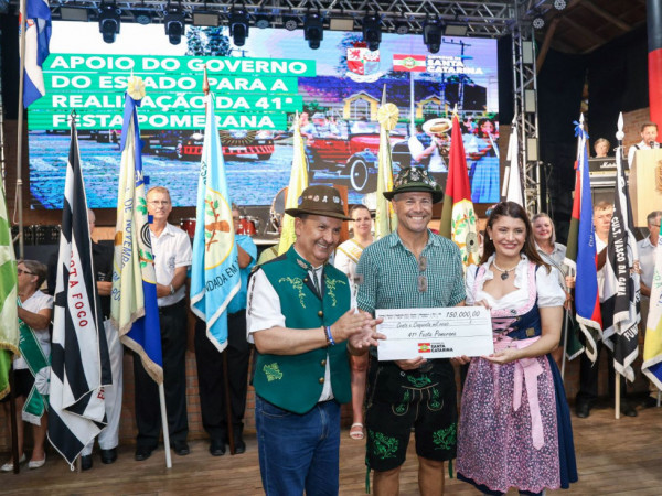 O ato simb&oacute;lico de descerramento da placa ocorreu durante o desfile oficial de abertura da festa.