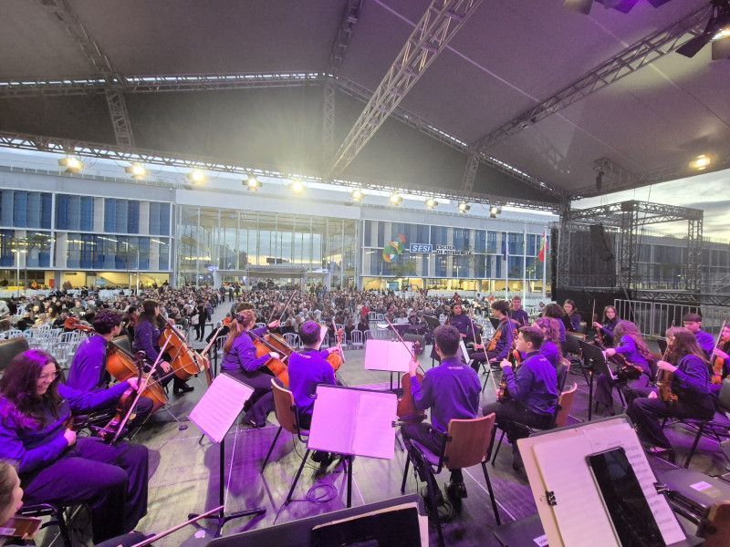Orquestra Musicarium diante da plateia na Escola SESI de Joinville em 2025.