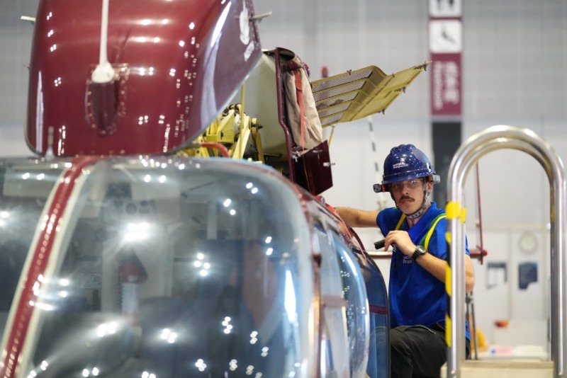 Catarinense ao lado de helicóptero durante prova na China.