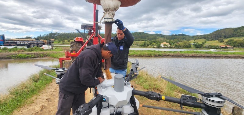 Momento do abastecimento do drone para a semeadura do arroz. 